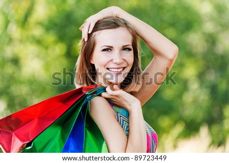 portrait young charming short-haired woman shopping bags behind background summer green park