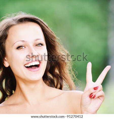 Portrait of young pretty laughing brunette woman showing \