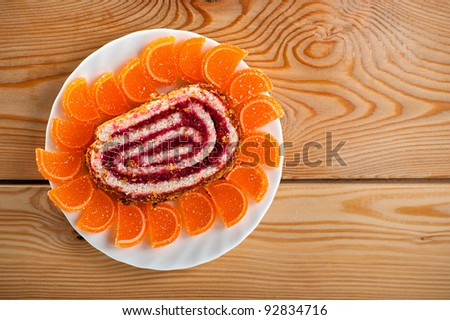 Tasty, colorful dessert: sweet rolls, orange marmalade on plate background wooden table