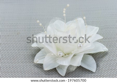 White artificial flower for wedding decorations on gray table.