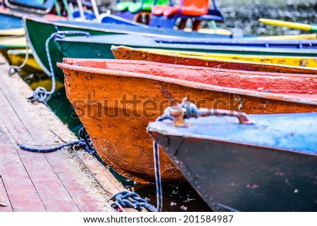 Colorful small boats parked to wooden pier. - stock photo