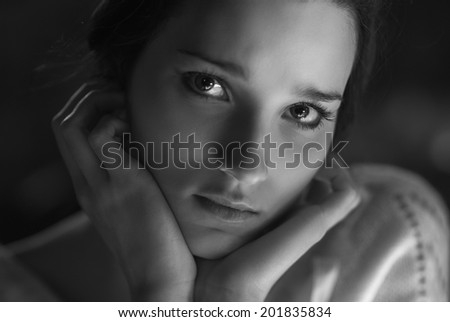 Young beautiful sad woman close-up, black-and-white image.