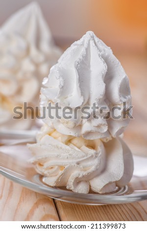 holiday dessert (meringue, whipped cream, ice cream) close-up on plate and wooden table