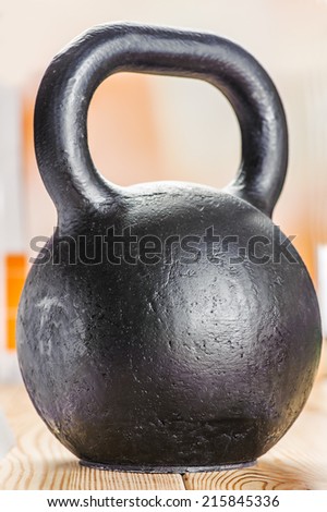 Large cast-iron sixteen pound weight on wooden table.