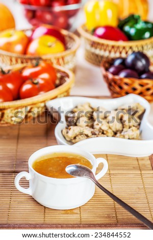 abundance food meat , vegetables, fruits (stewed chicken, tea, tomatoes, peppers, apples, plums) background wooden table