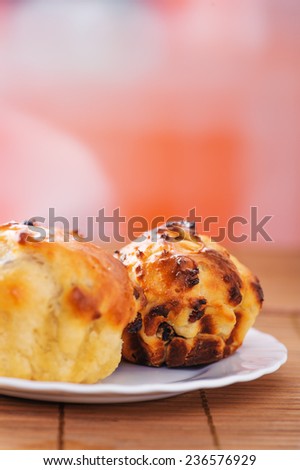 Small plates of muffins on ppink background.