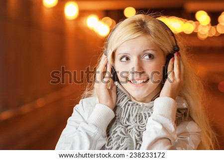 Beautiful woman in night tunnel listens to music through headphones.