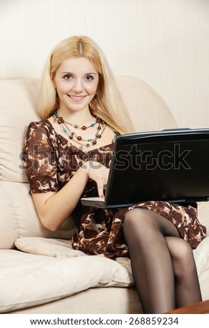Young charming fair-haired woman works on portable computer.