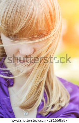 Young beautiful woman in bright yellow dress looks afar.