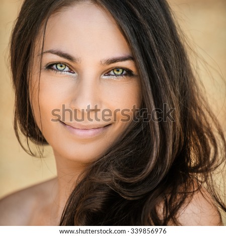 beautiful woman stands sideways dark hair bare shoulder smiling