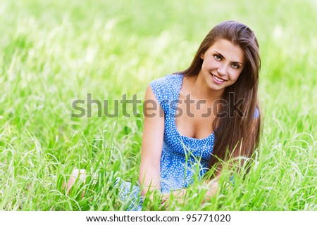 charming young dark-haired woman sitting green grass flower ear smiling background green meadow