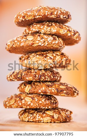 delicious oatmeal cookies with splash of sunflower seeds, sesame seeds on wooden table laid out in row