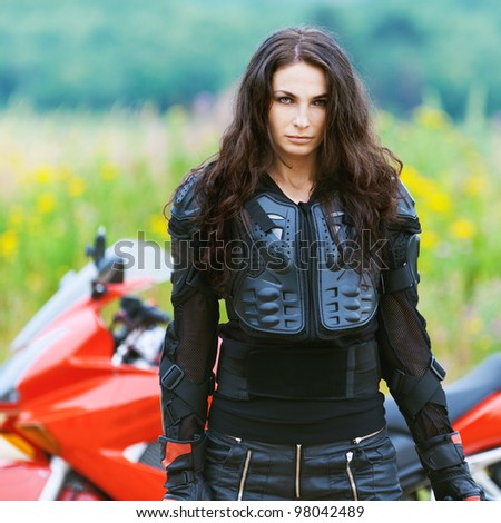 portrait beautiful sad dark-haired woman leather jacket standing alongside red motorcycle background summer green field