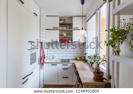 White kitchen with red components, cosy tiny home after the reconstruction in panel house