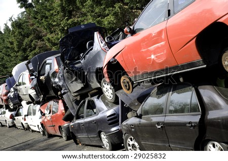 Scrapped cars in breakers yard piled on top of each other