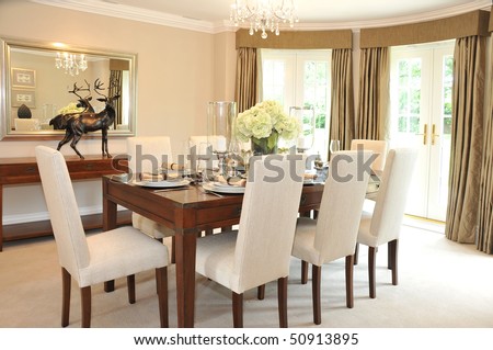 A luxurious dining room with table and chairs set for a meal