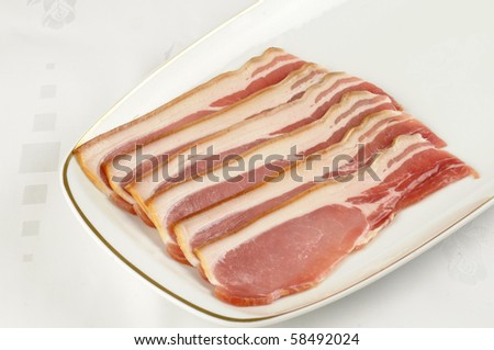 strips of uncooked smoked back bacon on a white serving plate
