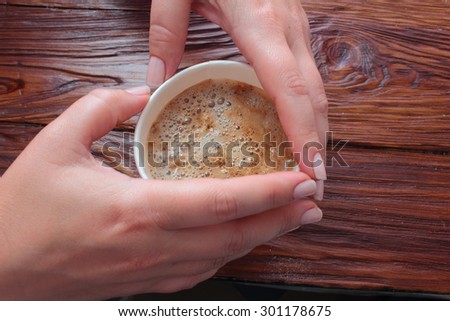 in both hands is a glass coffee