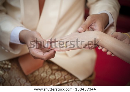 Marry me. Groom put a ring on finger of his lovely wife