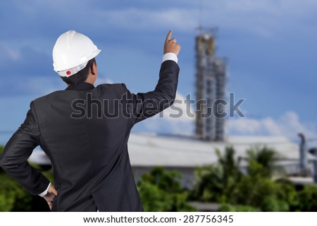 engineer in suit stand in front of construction site