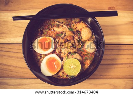 bowl of noodles with vegetables and soft boiled egg on wooden table. delicious noodle. Instant noodle. hot noodle.Homemade Quick Ramen Noodles with egg.vintage color