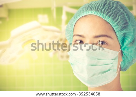 woman doctor looking at camera at hospital, close up shot on surgical room background vintage color