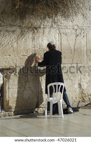 Man praying at the Western Wall of the Old City in Jerusalem.  Also known as the Wailing Wall.  It is regarded as the last remnant of the Holy Temple and Jewish pilgrims come here.