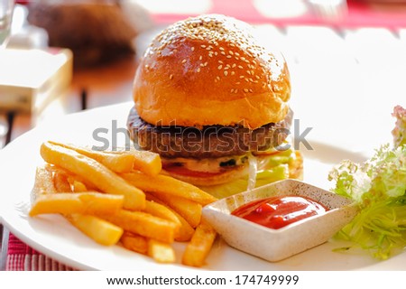 a beef cheeseburger in restaurant on table.