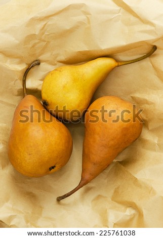 Three ripe pears over brown paper background. Above view