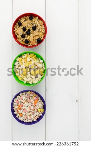 Three bowls of cereals over white wooden table with copy space (negative space)