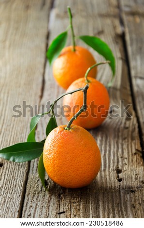 Three ripe tangerines in straight line on wooden table