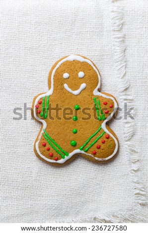 Homemade gingerbread man over white cloth, above view
