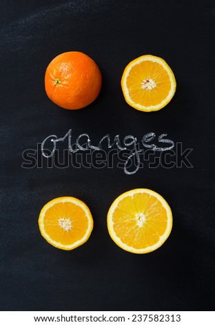 Orange fruits over black chalkboard with handwritten \