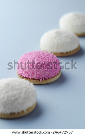 Marshmallow biscuits with pink sugar sprinkles over blue background
