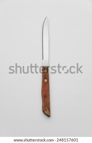 Silver knife with wooden handle over white background, top view