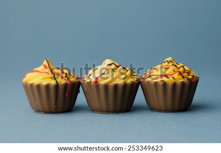 Three Chocolate Cup Cake over blue background