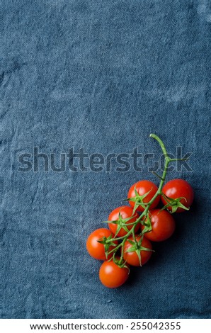 Cherry tomatoes over blue cloth, above view with lots of copy space
