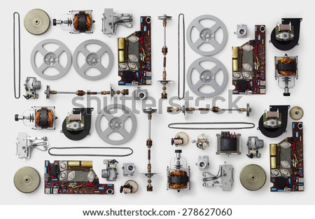 Parts of a vintage film projector well arranged over white background, above view. This is part of a larger series.