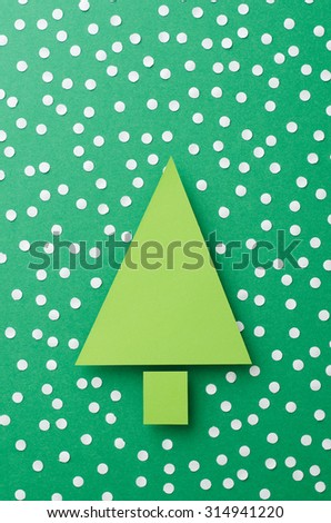Paper Christmas Tree and snow cut from green paper over green background,top view