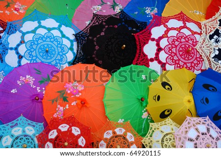 Different size, color and texture Chinese umbrellas arranged in sequence for display.