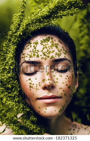 sensual healthy woman with plant on face