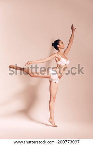 ballerina dancing in light sepia studio