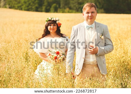 happy married couple on yellow summer field