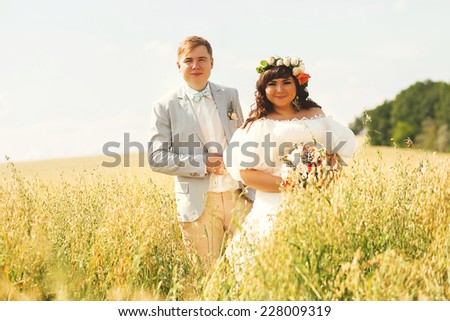 happy married couple on yellow sunny field