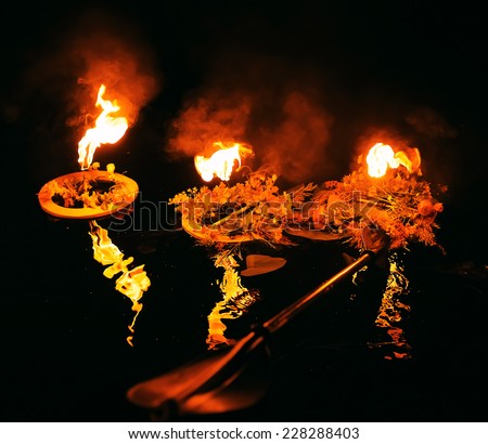 wreaths burning on river in the evening