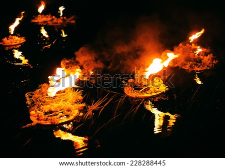 wreaths burning on dark river in the evening