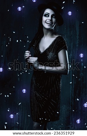 emotional smiling woman in black dress with violet lights in dark