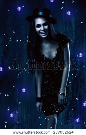smiling woman in black dress with violet lights in dark