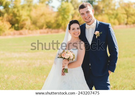 happy married couple on field in sunlight