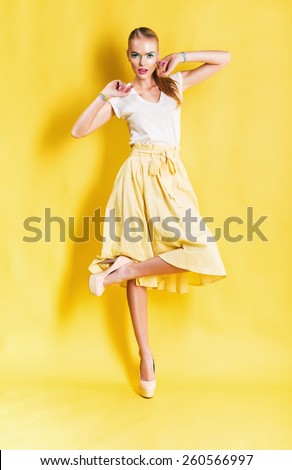 cute blond woman in yellow skirt on yellow background